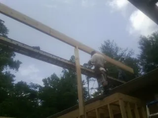 Carpenter setting a ridge beam over a new addition frame — Ice Dam Removal by Roofing Brothers in Lyndhurst